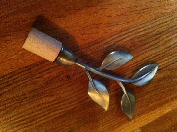 And this is how the stair books stay in place. I took a decorative end of the a a curtain rod and screwed it into a wooden dowel. The dowel goes in the holes where the bannister supports used to be.  Yep. I'm crafty. 